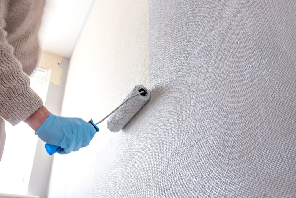 Een muur bedekt met overschilderbaar bouwbehang, klaar om te worden geschilderd in een kleur naar keuze, waardoor een flexibele en aanpasbare muurdecoratie ontstaat.
